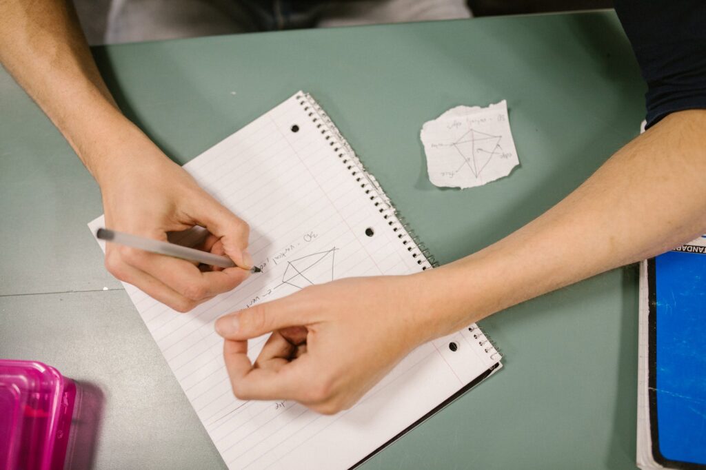 student making a cheat sheet on a piece of paper